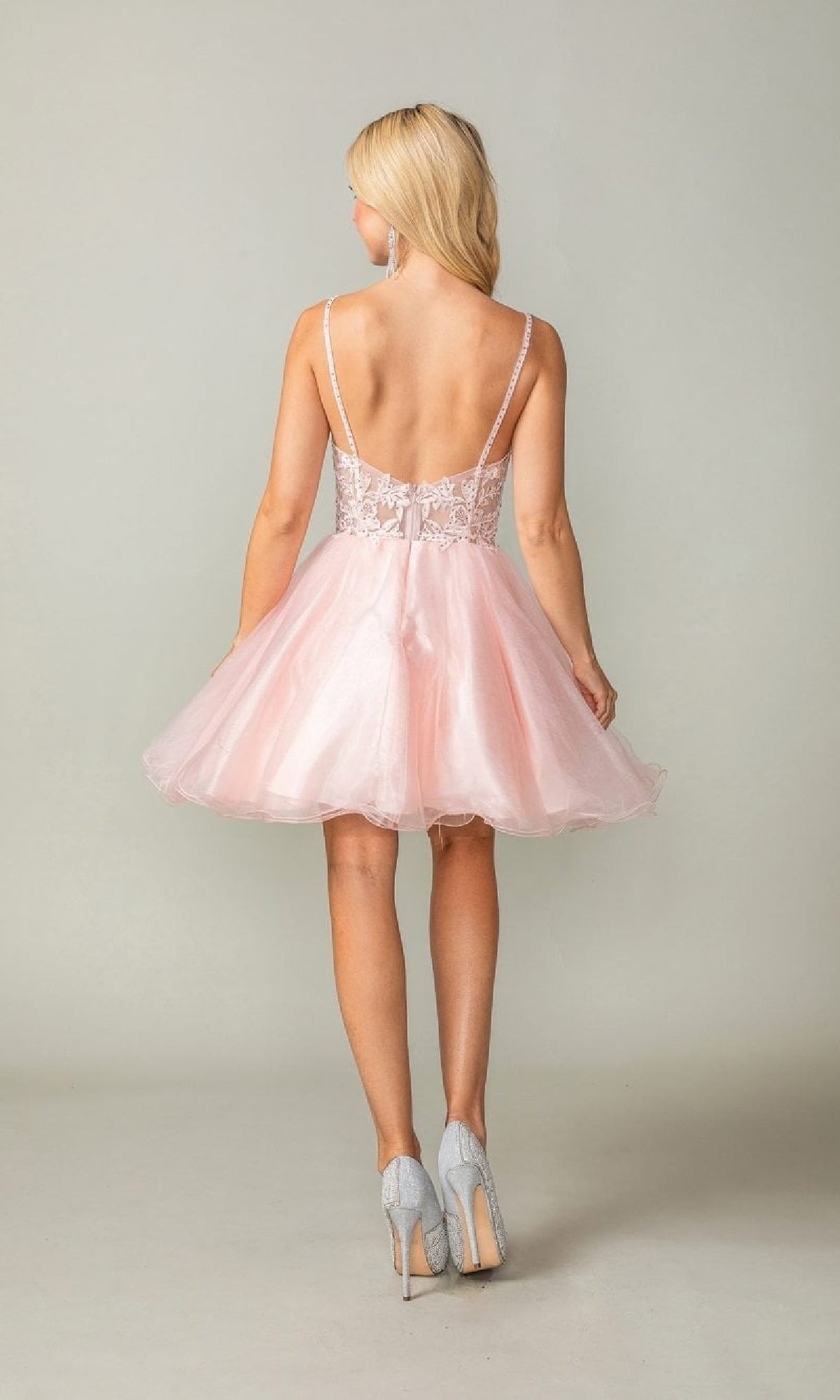 Woman wearing a pink dress with a plain background